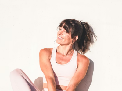 woman smiling against a wall