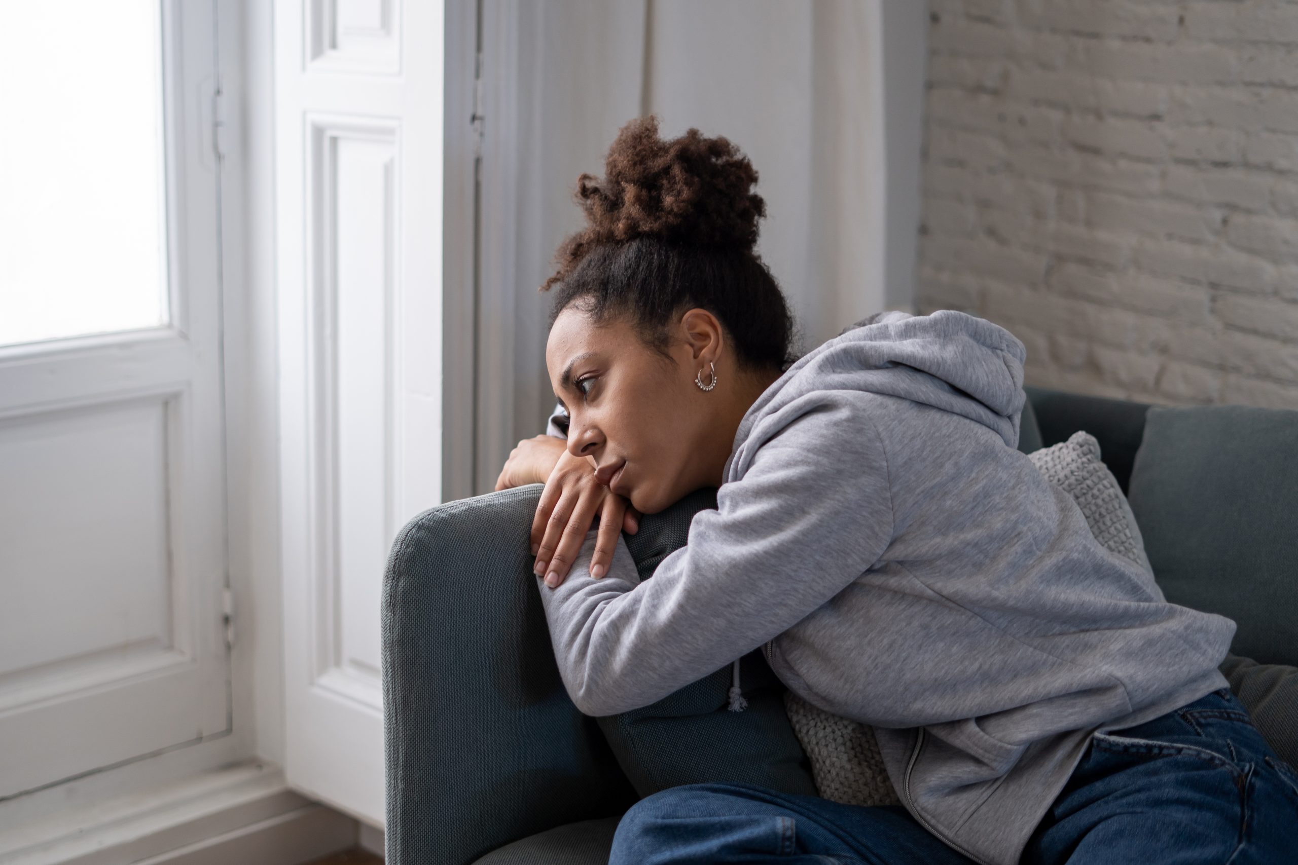 Sad woman suffering from depression symptoms feeling distressed alone at home.