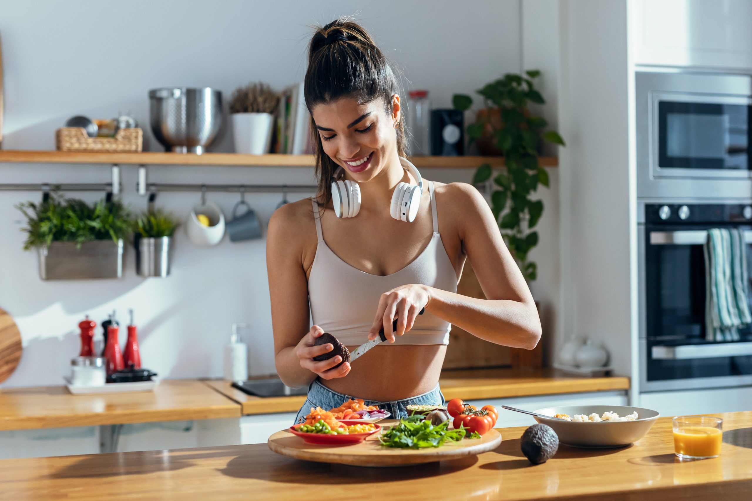 Fitness woman making a healthy poke bowl in the kitchen at home.