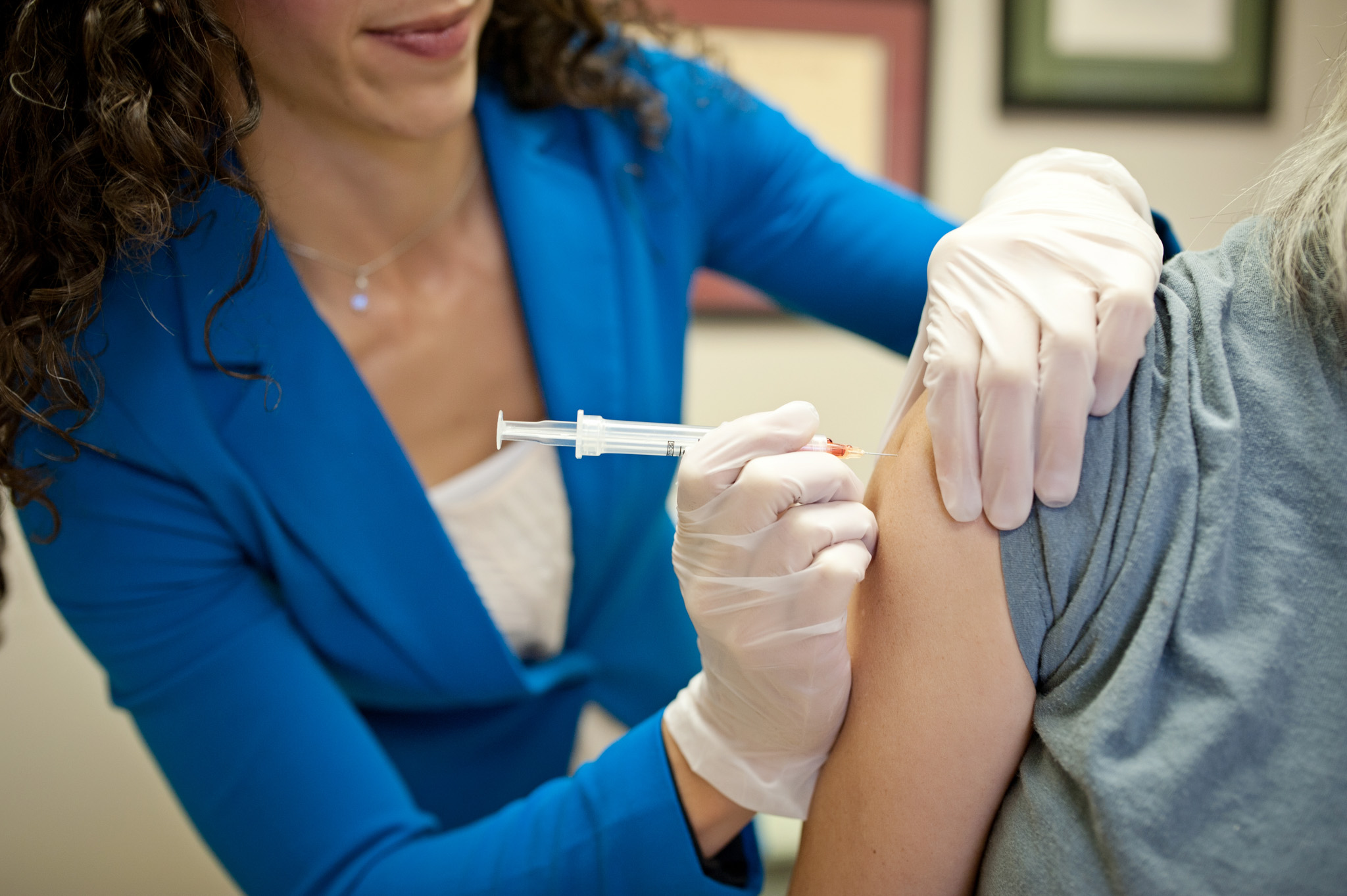 Dr. Lisa administers a B12 injection into a patient’s upper arm.